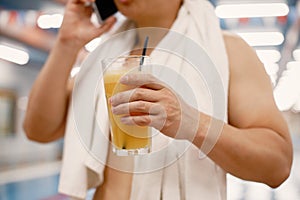 Cropped photo of a man standing in swimming pool holding a glass with juice photo