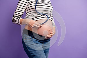 Cropped photo of pregnant lady hold stethoscope hear tummy wear striped shirt isolated purple color background