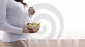 Cropped photo of pregnant woman holding bowl with vegetable salad