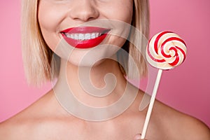 Cropped photo of seductive cheerful girl naked shoulders smiling enjoying lollipop caramel isolated pink color