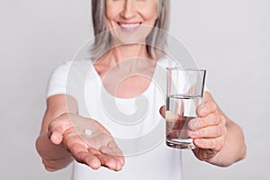 Cropped photo of senior woman happy positive smile hold hand suggest meds pills water isolated over grey color