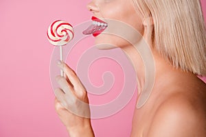 Cropped photo of sexy seductive girl naked shoulders stick out enjoying lollipop caramel isolated pink color background