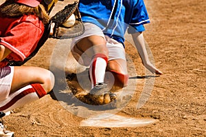Cropped photo of softball player sliding into home plate