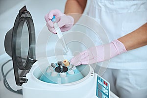 Experienced dermatologist preparing the serum using the medical equipment photo