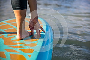 Cropped picture of woman in her SUP Yoga practice on the water