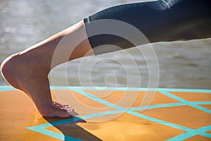 Cropped picture of woman in her SUP Yoga practice on the water photo
