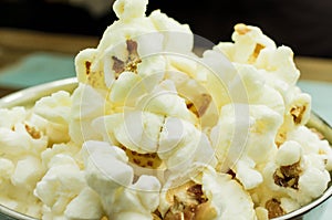 Cropped Popcorn in a silver bowl over wood background