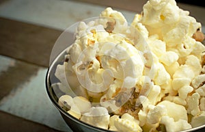 Cropped Popcorn in a silver bowl over wood background