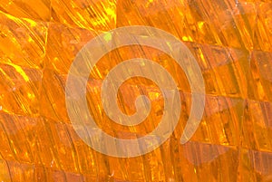 Cropped portion of an orange lens of a construction barricade light
