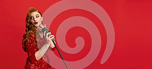 Cropped portrait of enthusiastic female jazz singer on stage isolated over red background. Flyer