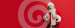 Cropped portrait of senior man wearing Santa Claus costume, holding lager foamed beer glass. Oktoberfest. Flyer