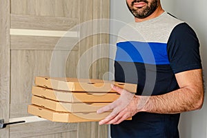 Cropped portrait of smiling bearded man holding pizza boxes in hands. Food order and delivery