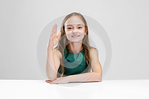 Cropped portrait of studious pupil, girl raising hand to answer  over white background