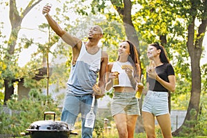 Cropped portrait of three friends taking selfie outdoors