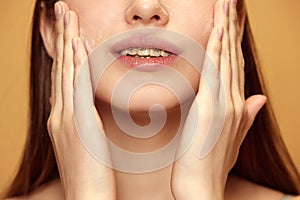 Cropped portrait of young woman applying cream to facial skin to maintain its healthy and radiant appearance against