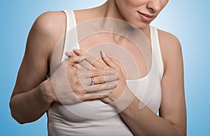 Cropped portrait young woman with breast pain touching chest photo