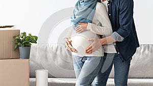 Cropped of pregnant couple posing at new house