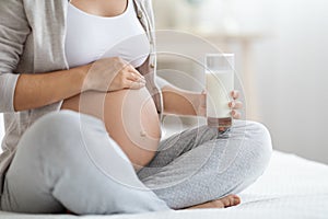 Cropped of pregnant woman holding glass of milk