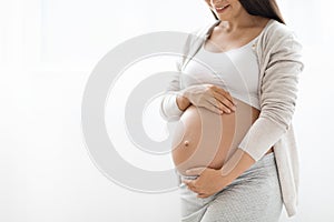 Cropped of pregnant woman touching her big belly