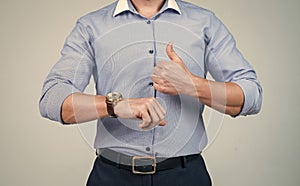 cropped punctual man in shirt check time on hand watch and show thumb up, punctuality