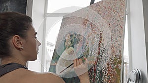Cropped rear view shot of a woman painting at art studio