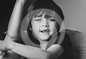 Cropped short kid looking at camera with smiling face,Candid short child showing lost his baby front teeth with big smile, close