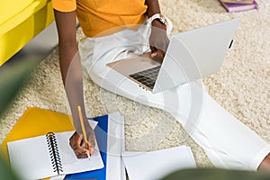 cropped shot of african american freelancer remote working on floor