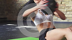 Cropped shot of an athletic woman doing crunches using medicine ball