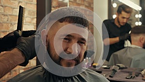 Cropped shot of barber cutting hair to satisfied client