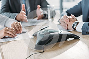 cropped shot of business people having conversation and using speakerphone