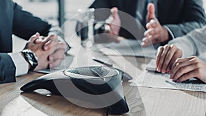 cropped shot of business people having conversation and using speakerphone