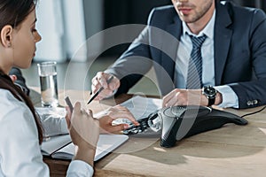 cropped shot of businessman and businesswoman using conference