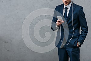 cropped shot of businessman listening music with headphones