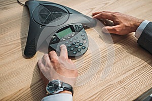 cropped shot of businessman with stylish wristwatch using speakerphone