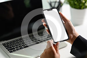 Cropped shot businessman using mobile phone at office desk. Empty screen for your text message