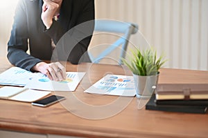 Cropped shot businesswoman analysis financial statements data paper photo