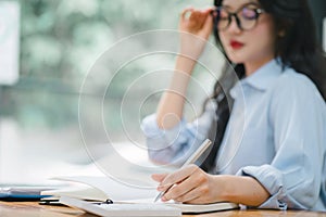 Cropped shot of businesswoman is working at her desk, using a calculator to perform calculations. Finance and accounting