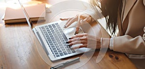 Cropped shot of businesswoman working on her project while typing on laptop computer in comfortable office