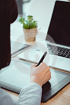 cropped shot of designer drawing on graphics tablet photo