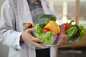 Cropped shot of dietitian holding a bowl of vegetables for healthy eating and diet