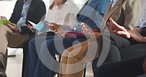 Cropped shot of diverse group of business people sitting in row in audience at business conference