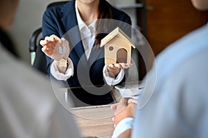 Cropped shot, An expert female real estate agent holding a house model and house key