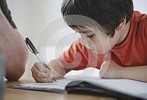 Cropped shot father helping his boy with homework, Dad and Son doing homework together, Teacher teaching little boy how to write.