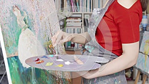 Cropped shot of a female artist mixing paint on her palette while drawing