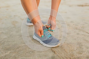 cropped shot of female athlete tying shoelaces