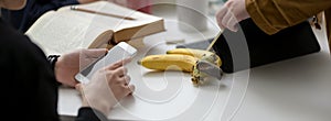 Cropped shot of female college students working together on their thesis on white table