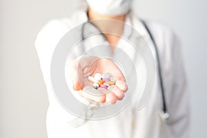 Cropped shot of a female doctor displaying a handful of tablets and pills in her palm