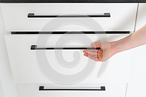 closeup of woman opening drawer on kitchen