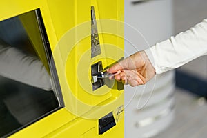 Cropped shot of female hand inserting credit card into automatic terminal machine