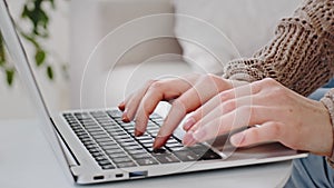 Cropped shot of female hands typing text on computer keyboard indoor, close-up fingers of Caucasian young woman girl